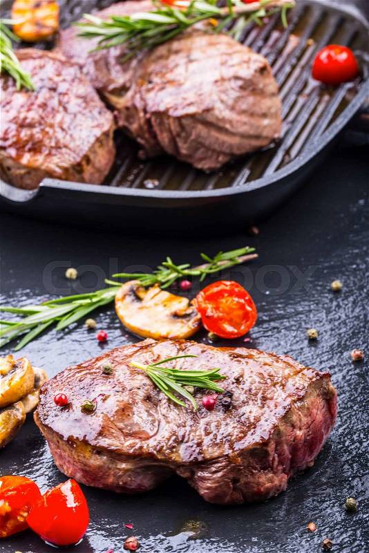 Grill beef steak. Portions thick beef juicy sirloin steaks on grill teflon pan or old wooden board, stock photo
