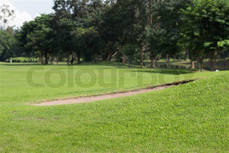 Golf course with sand bunker and green grass, stock photo