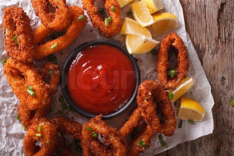 Fried calamari breaded close-up on a table, and tomato sauce. horizontal view from above , stock photo
