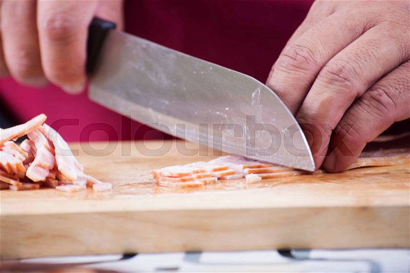 Closed up Chef cutting bacon with knife before cooking / cooking spaghetti concept, stock photo