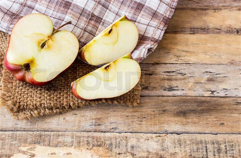 Close up of a sliced red apple on a wooden table. Fresh red apple on old wooden table background. Red apple on wood table. Healthy concept, stock photo