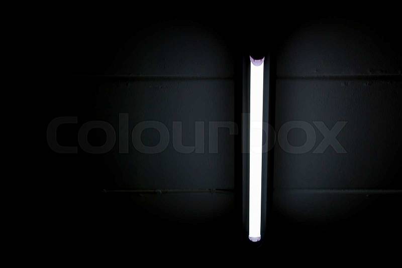Detail of a fluorescent light tube mounted on a wall with copy space for any design, stock photo