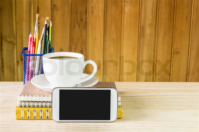 Smart phone,coffee cup,and stack of book on wooden table background. Business concept, stock photo