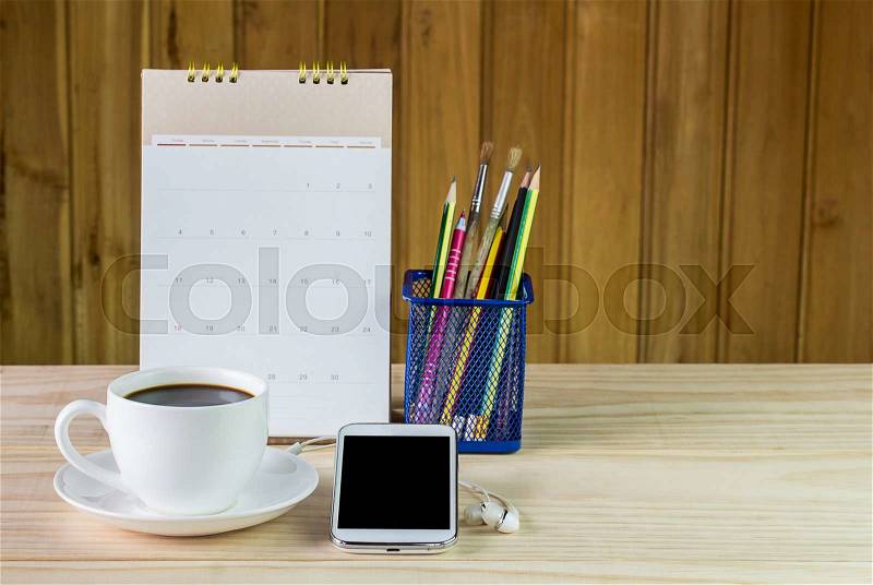 Smart phone,coffee cup,and calendar on wooden table background.Business concept, stock photo