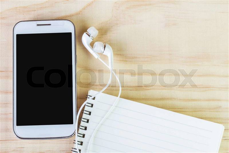 Smart phone and open notebook on wooden table. top view, stock photo