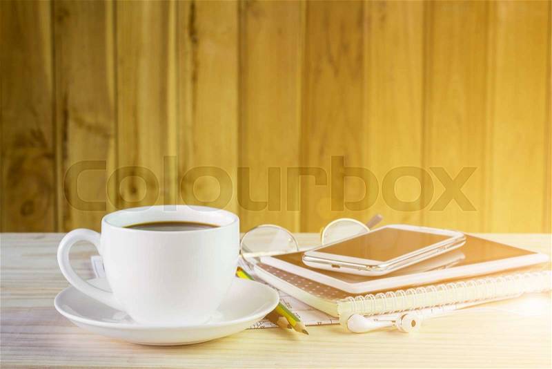 Cup of coffee with note book on wooden table background. Business concept, stock photo