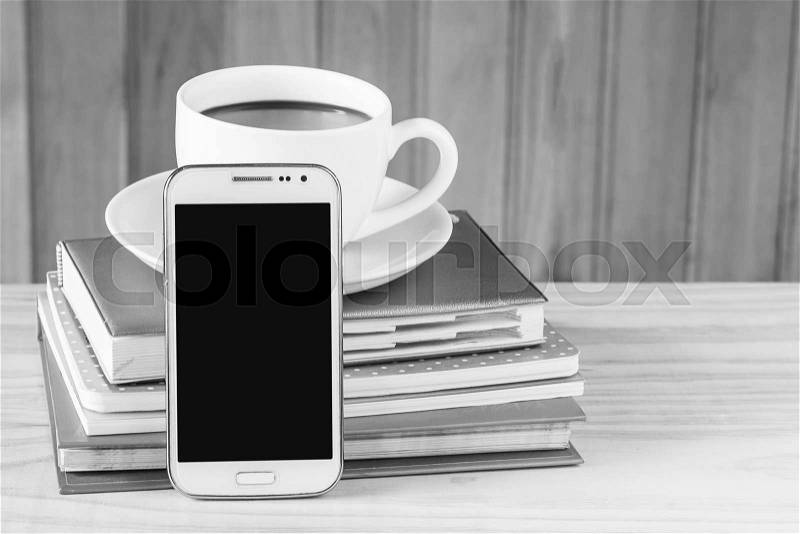 Smart phone, coffee and note book on wood table background. Business concept.black and white tone, stock photo
