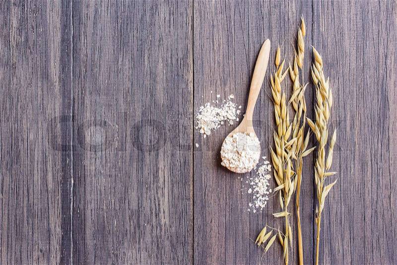 Rolled oats and oat ears of grain on a wooden table, with copy space. ears of wheat on the table, stock photo