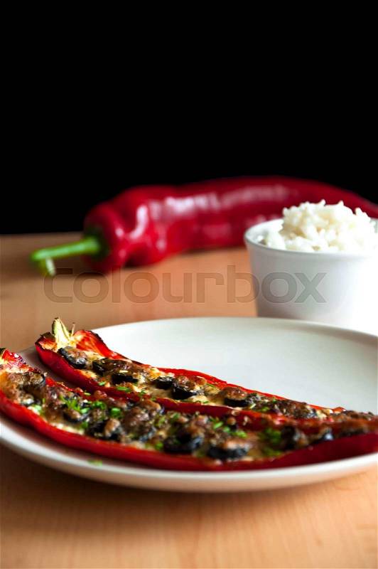 Baked bell pepper with cheese and olives, rice in bowl, stock photo