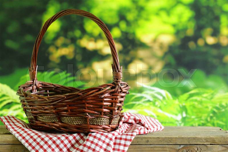 Empty wicker basket and checkered plaid for picnic, stock photo