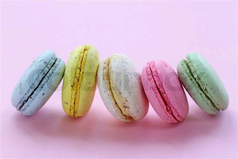 French multicolored almond cookies macaroons on a pink background, stock photo