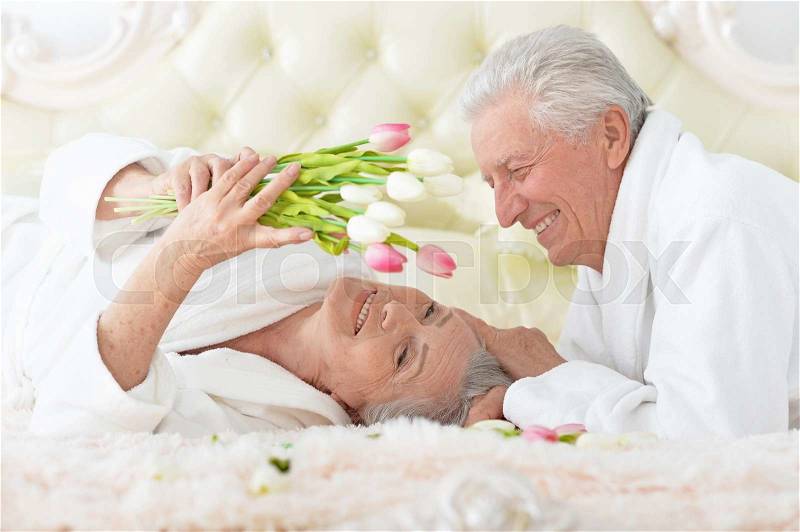 Happy senior man gives flowers to a woman, stock photo