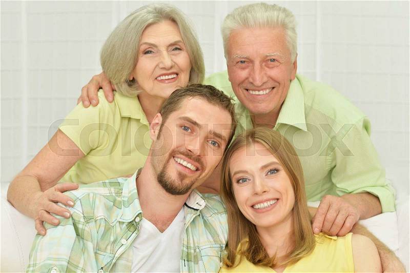 Portrait of a cheerful young couple with senior parents, stock photo