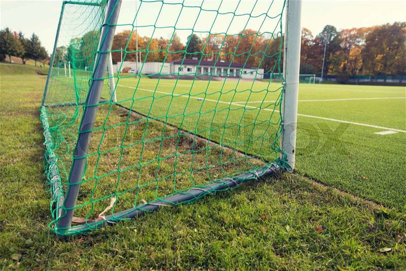 Sport and equipment concept - close up of football goal on field, stock photo