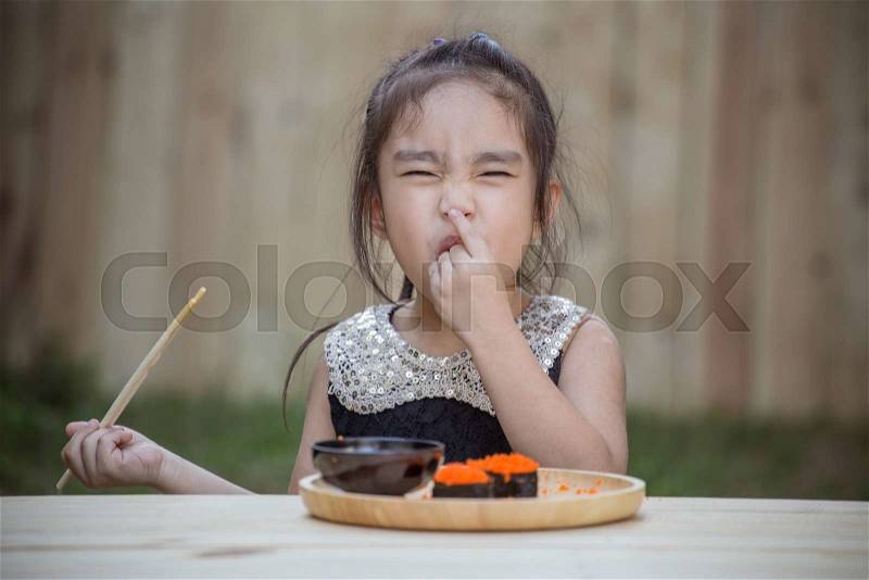 Portrait of adorable little girl feel happy eating sushi, stock photo
