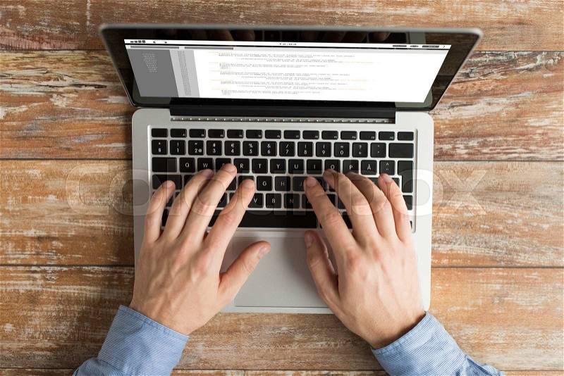 Business, programming, people and technology concept - close up of male hands typing on laptop with coding on screen on table, stock photo