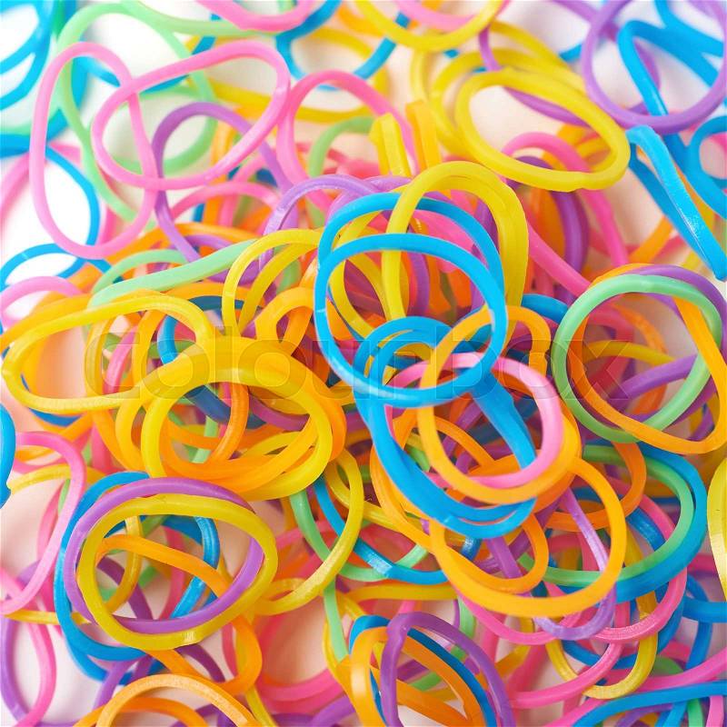 Surface covered with multiple colorful resin loom bands, close-up crop fragment, stock photo