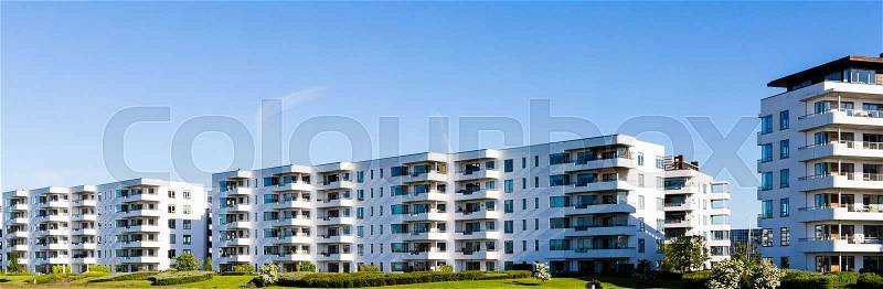 Contemporary white residential building against a blue sky. Ideal for illustration of real estate or investment concepts, stock photo