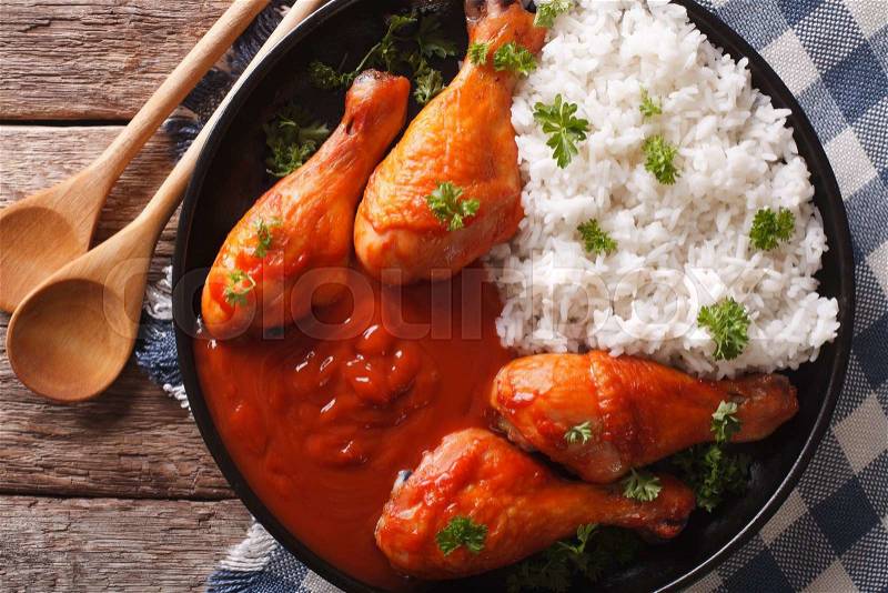 Baked chicken with chilli sauce Sriracha and Rice close-up on the table. horizontal view from above , stock photo