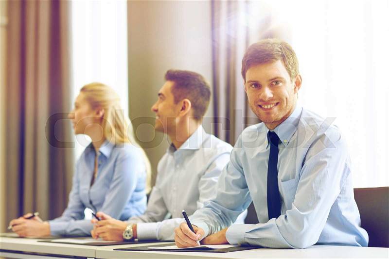 Business, people and teamwork concept - group of smiling businesspeople meeting on presentation in office, stock photo