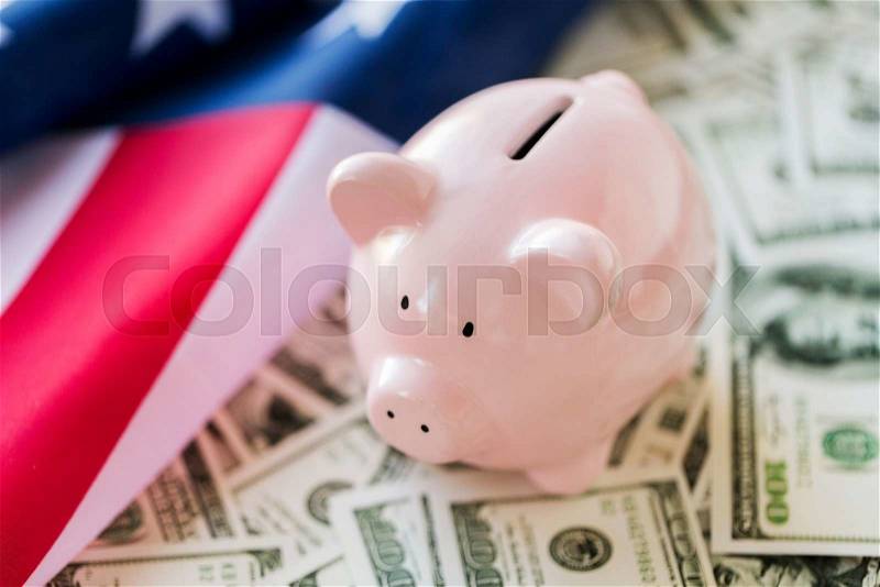 State budget, finance, saving and nationalism concept - close up of american flag, piggy bank and dollar cash money, stock photo