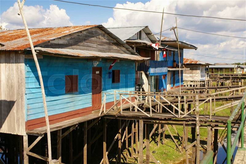 Houses on stilts rise above the polluted water in Islandia Peru, stock photo
