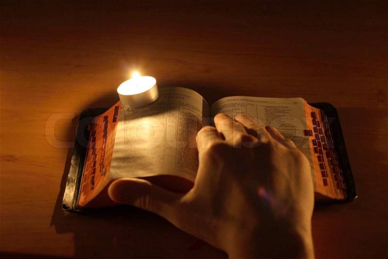 Hand, Bible and candle, stock photo