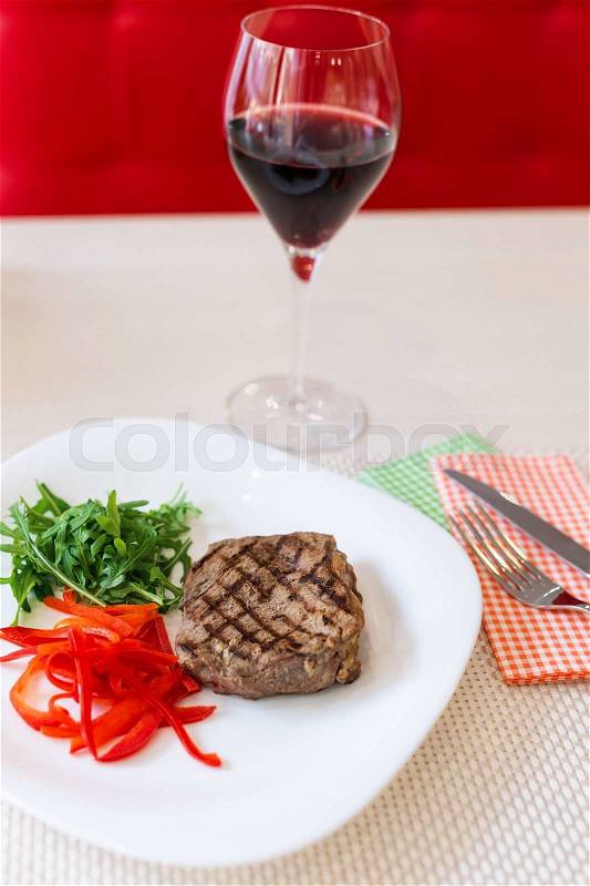 Steak with vegetables served with red wine in a restaurant, stock photo