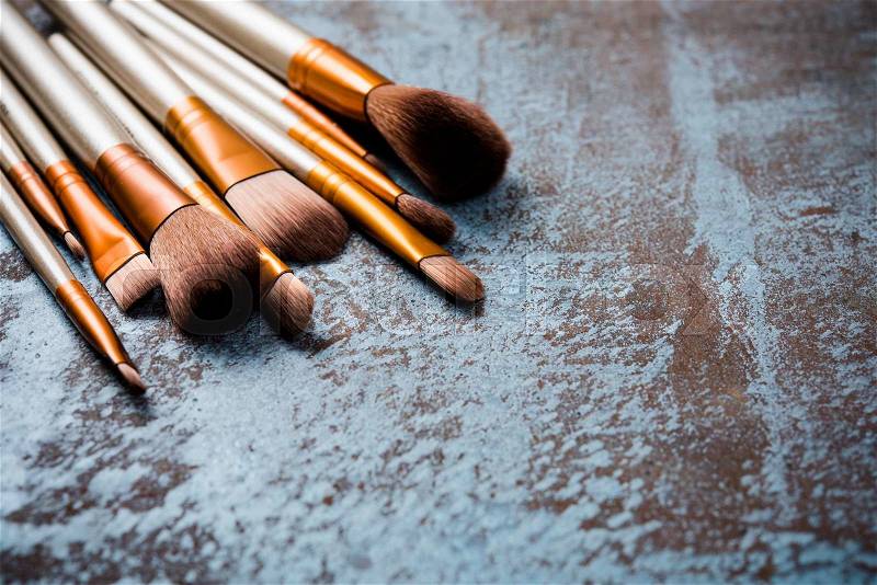 Professional makeup brushes collection, new make-up tools set on painted background with copy space, stock photo