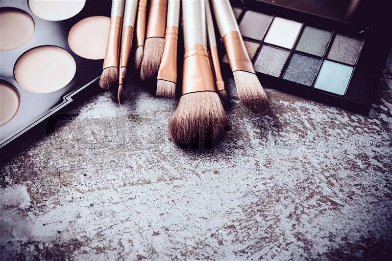 Professional makeup brushes and tools collection, make-up products set on metal painted background, stock photo