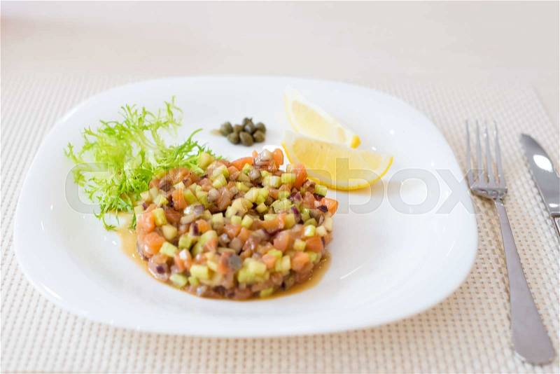 Vegan salad with lemon on white plate in restaurant, stock photo
