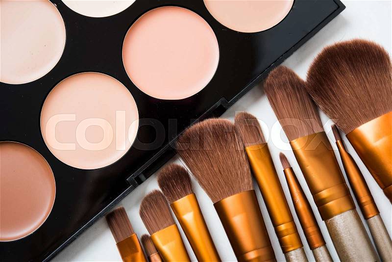 Professional makeup brushes and tools, natural make-up products set, eyeshadows and concealers on white table, stock photo