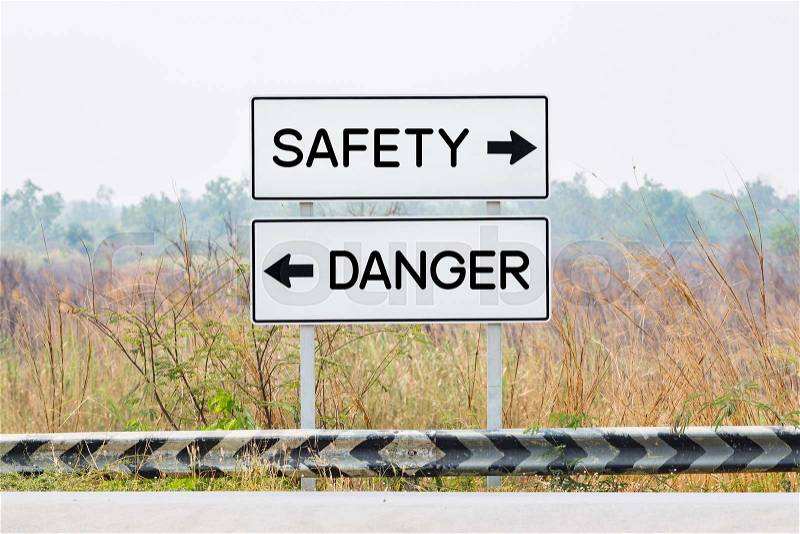 Road sign boards with danger and safety text, opposite wording concept, stock photo