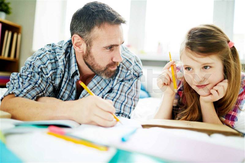 Man and his daughter thinking of what to draw, stock photo