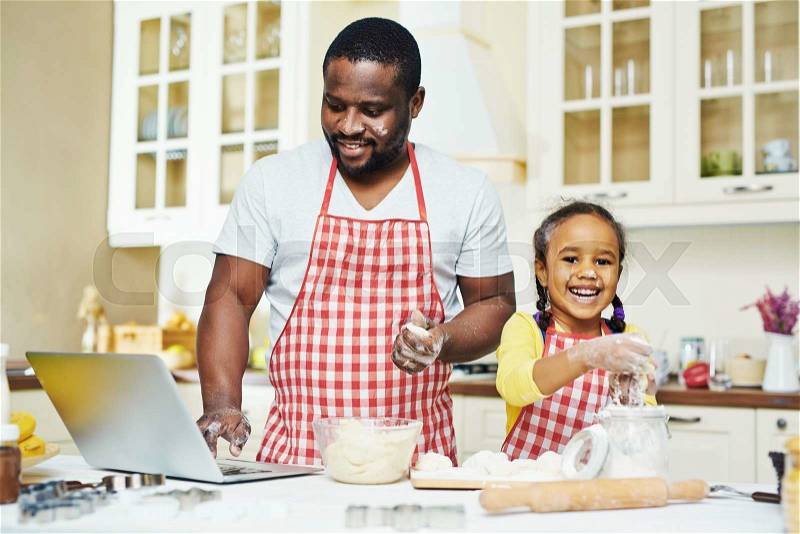 Cute daughter with dough and her father cooking pastry together, stock photo