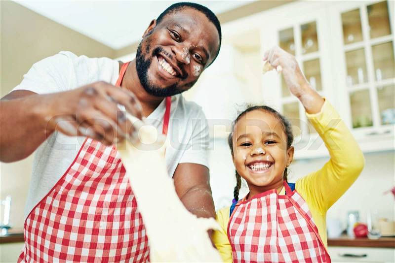 Happy man with dough and his daughter looknig at camera, stock photo
