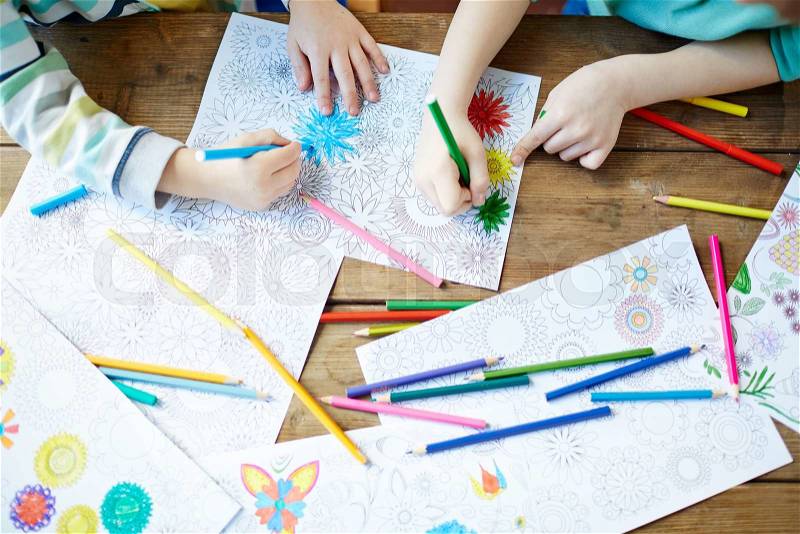 Kids coloring pictures with crayons and highlighters, stock photo