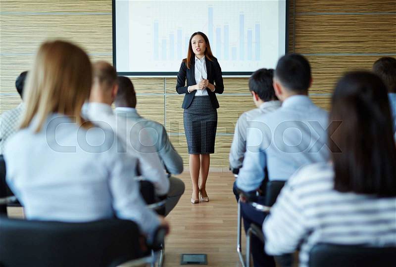 Female teacher or speaker explaining project to managers, stock photo