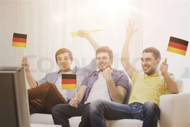 Friendship, sports and entertainment concept - happy male friends with flags and vuvuzela supporting football team at home, stock photo