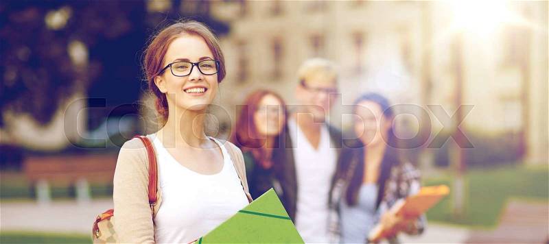 Education, campus, friendship and people concept - group of happy teenage students with school folders, stock photo