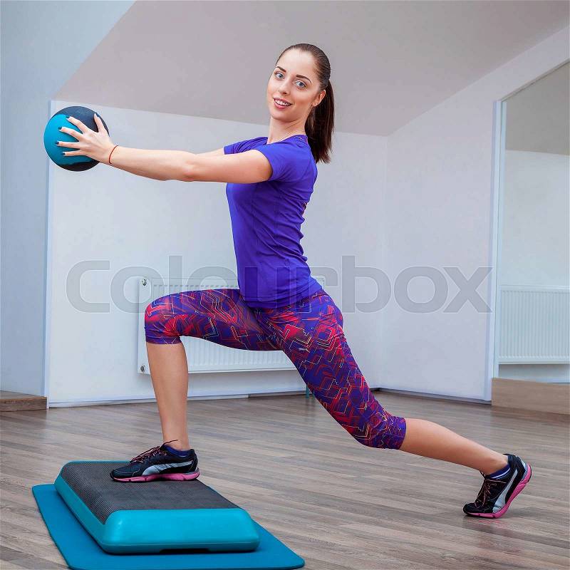 Fitness girl, wearing in sneakers, posing on step board with ball, the sport equipment background, gym, stock photo