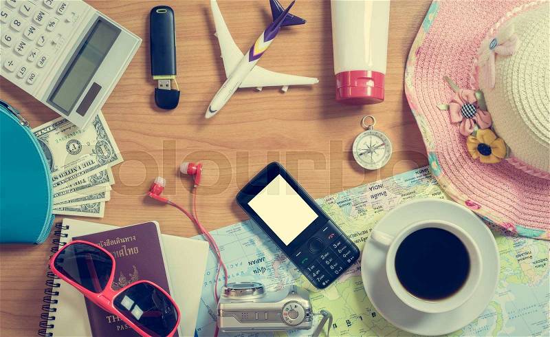 Set of travel accessory and cup of coffee on wooden vintage background, stock photo