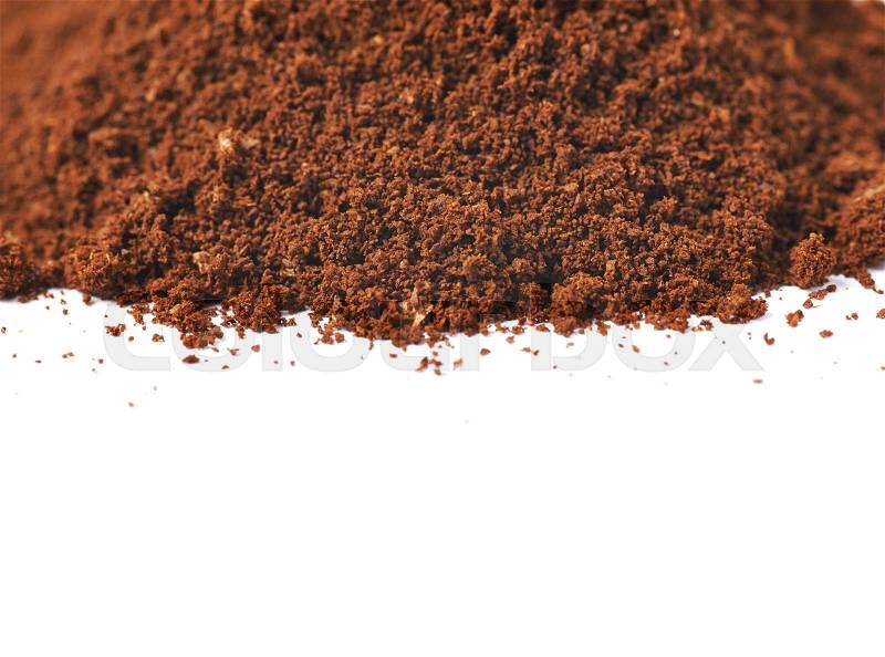 Pile of the ground coffee flakes isolated over the white background, close-up crop composition, stock photo
