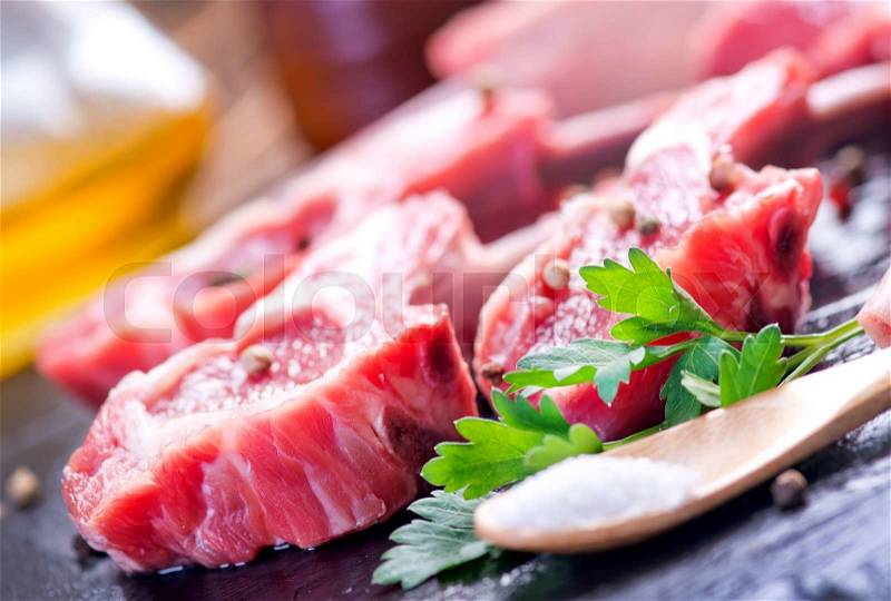 Raw meat with spice on wooden table, stock photo