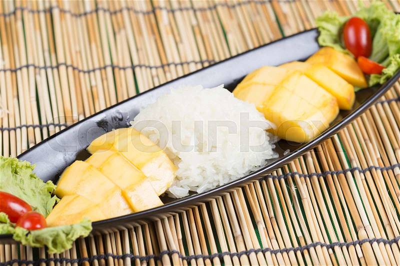 Ripe mango and sticky rice cooked with coconut milk ,Thai dessert , stock photo