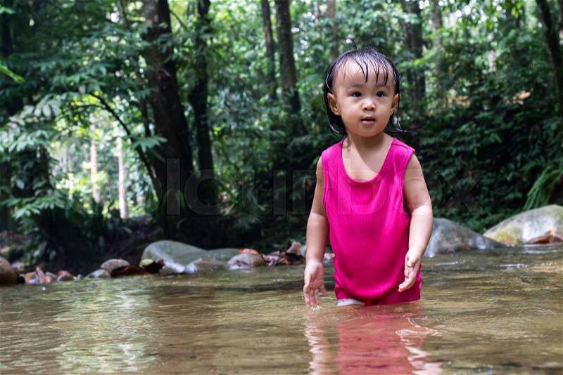 Asian Little Chinese Girl Playing in Creek in the Forest, stock photo