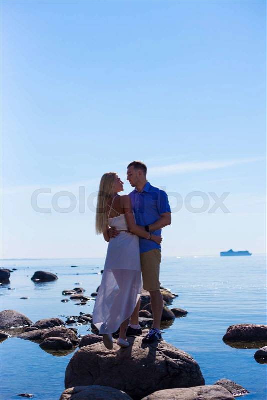 Silhouette of young couple in love over beautiful sea background, stock photo