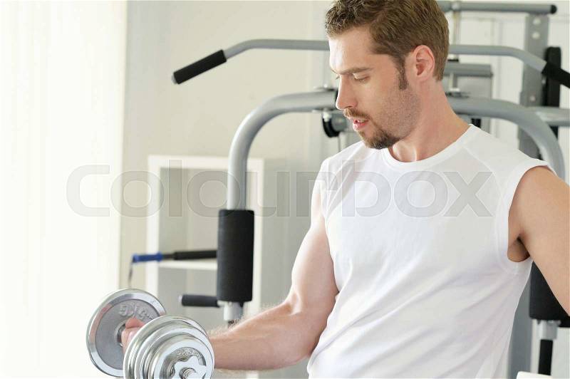 Man with weight training equipment on sport gym club, stock photo