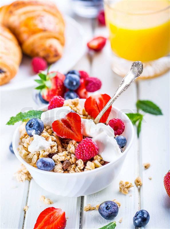 Muesli with yogurt and berries on a wooden table. Healthy fruit and cereal brakfast, stock photo