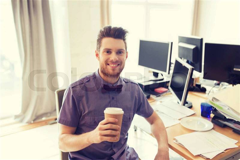 Business, startup and people concept - happy businessman or creative male office worker with computers drinking coffee, stock photo